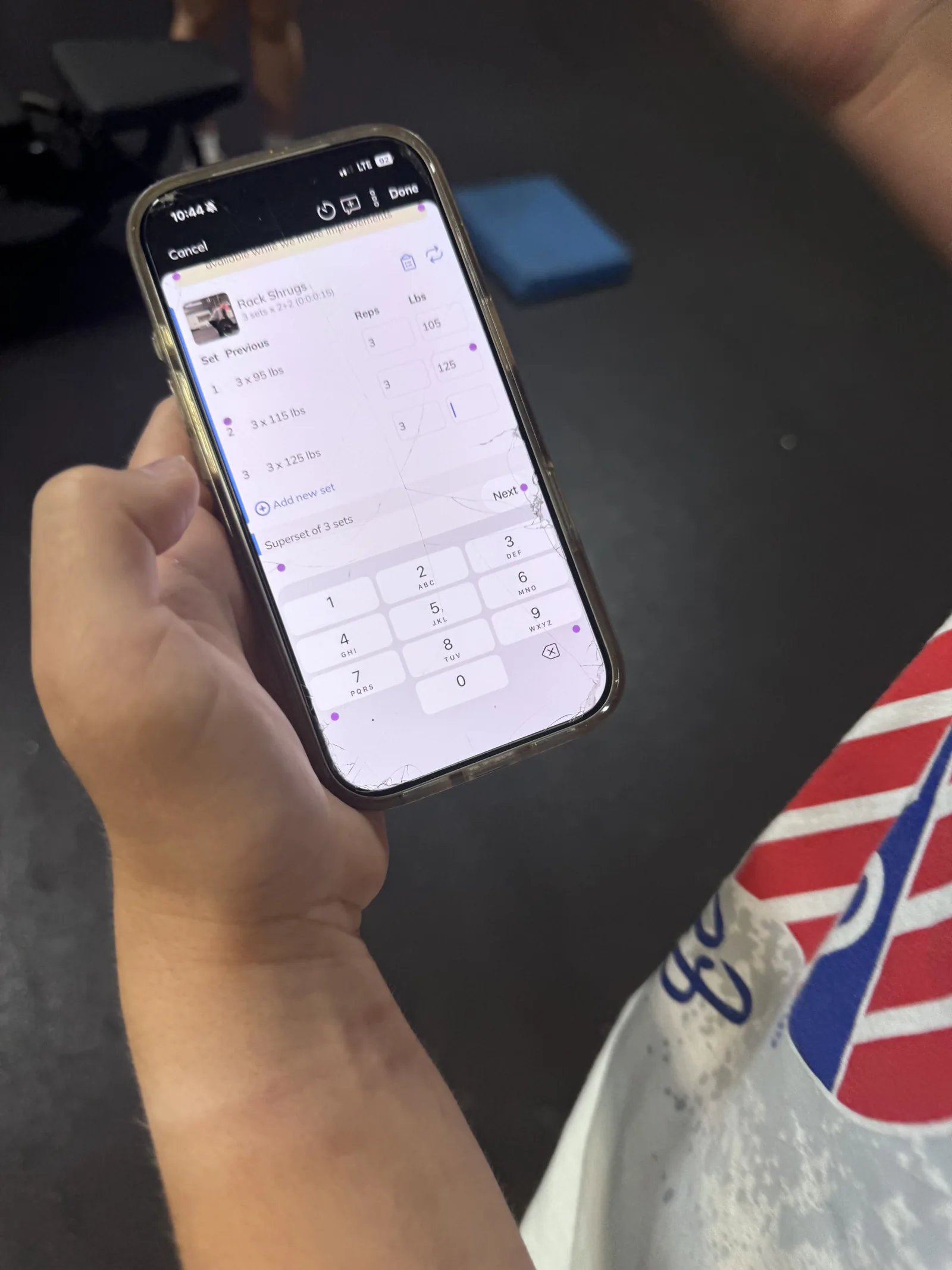 A phone showing an athlete's logged sets, reps and weights for the session
