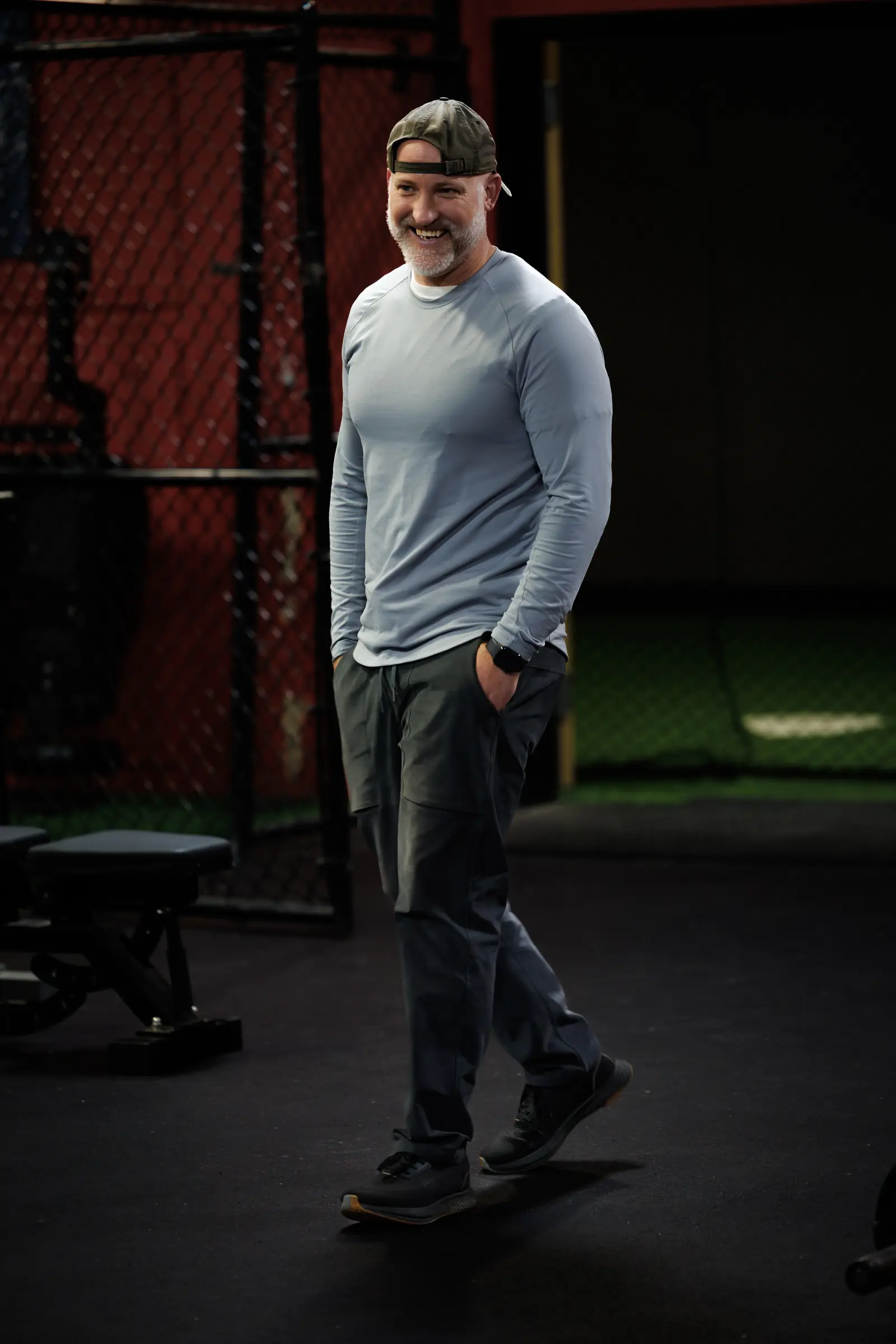 Coach Aaron Larmore walking through the training floor, smiling