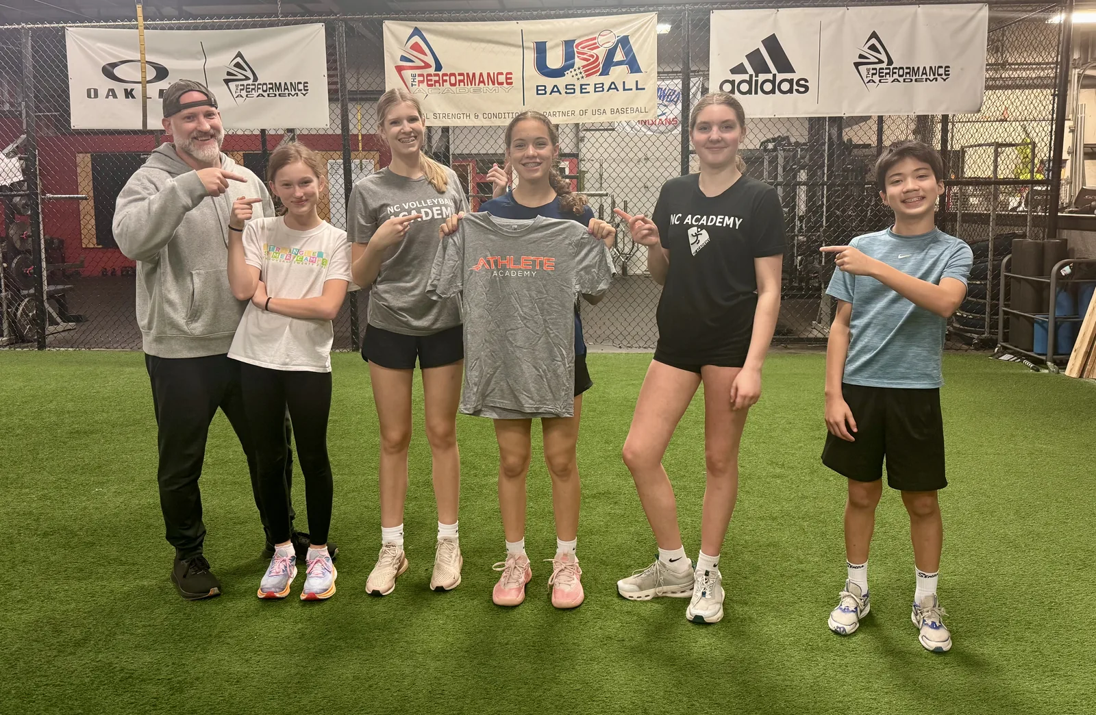 A group of club athletes standing together on the turf after a training session